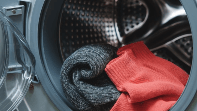 a close-up of a red sweater and a black sock in a washing machine