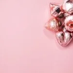 A cluster of pink Christmas ornaments on a plain background, offering elegant festive decor ideas.