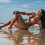Woman in a bikini enjoying a sunny day at Cabo Frio beach, Brazil.