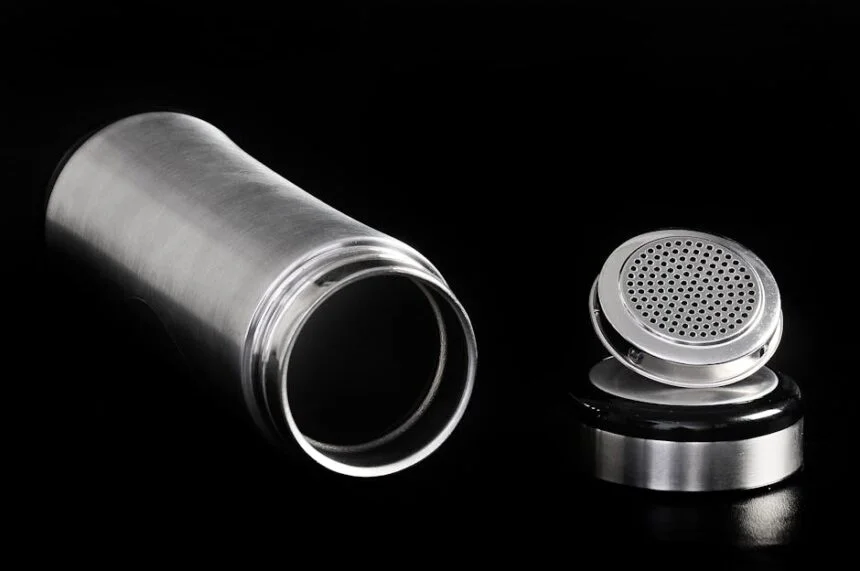 A sleek stainless steel thermos flask and cap displayed on a black backdrop, highlighting modern design.