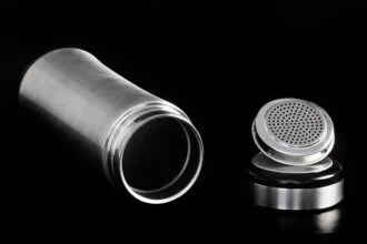 A sleek stainless steel thermos flask and cap displayed on a black backdrop, highlighting modern design.