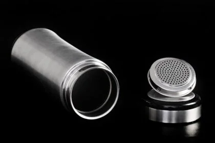 A sleek stainless steel thermos flask and cap displayed on a black backdrop, highlighting modern design.