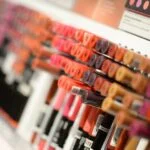Close-up of diverse lipsticks in a store showcasing various shades and brands for beauty enthusiasts.